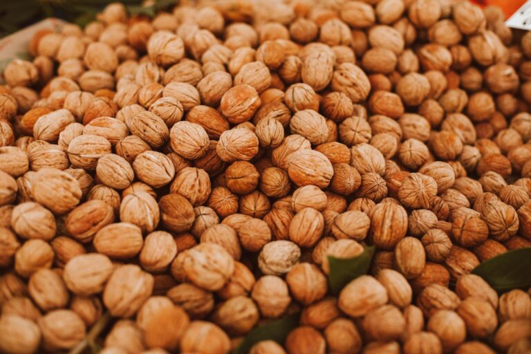A mix of organic nuts including almonds, cashews, pistachios, and walnuts in wooden bowls